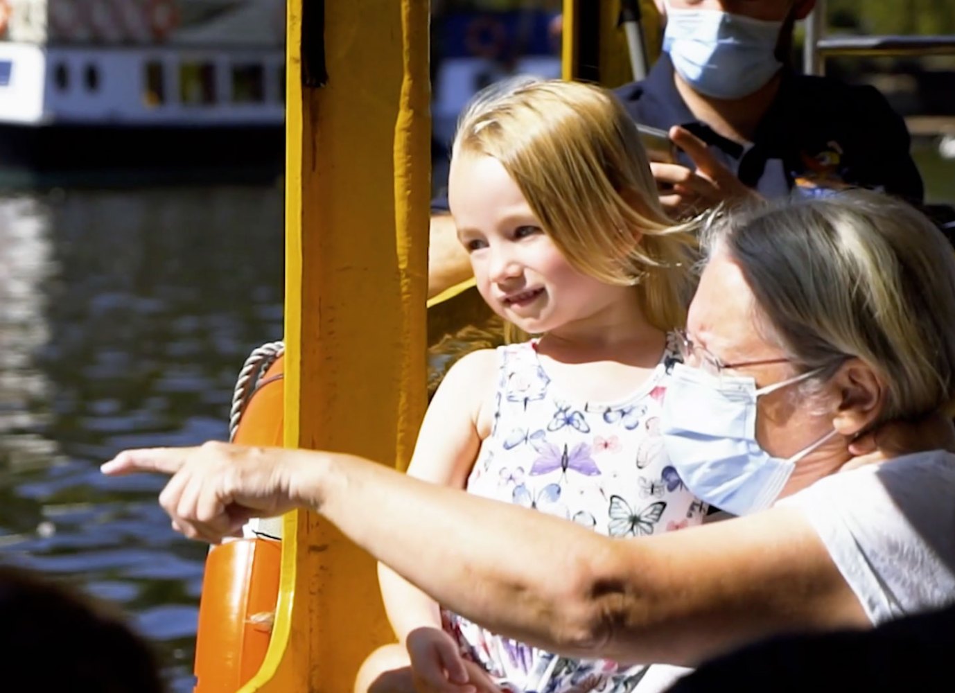 a little girl riding on the back of a boat