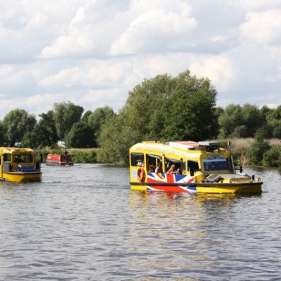 a bus traveling down a river next to a body of water