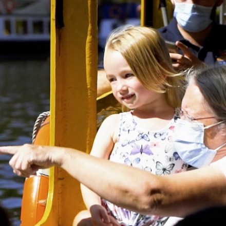 a little girl riding on the back of a boat