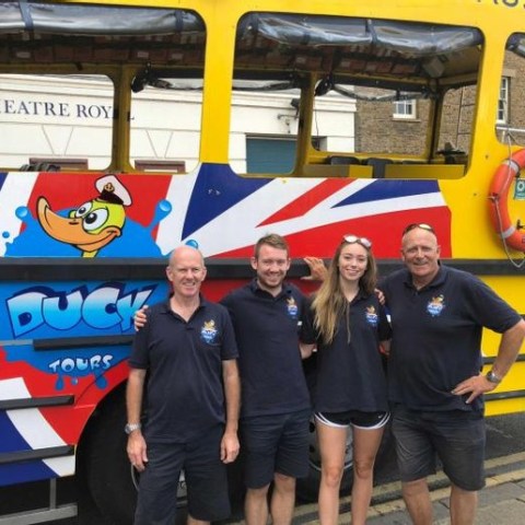 a group of people standing in front of a school bus